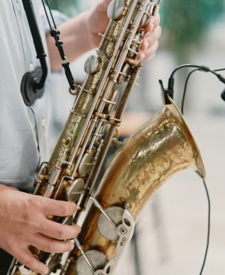 Saxophonist plays the saxophone on stage. Cropped